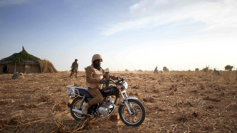 Foto AFP, Michele Cattan: iEen soldaat van het Burkinese leger op patrouille in het noorden van Burkina Faso. Jihadistische activiteiten in de regio maken werk bijzonder moeilijk.