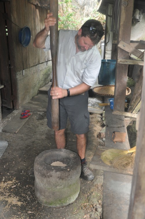 Docent Steven probeert de lokale techniek uit voor het klaarmaken van rijst. In een eerste fase worden de omhulsels van de rijstkorrels verwijderd. Nadien worden de omhulsels en de rijstkorrels van elkaar gescheiden. Een zwaar en moeilijk karwei, zo bleek