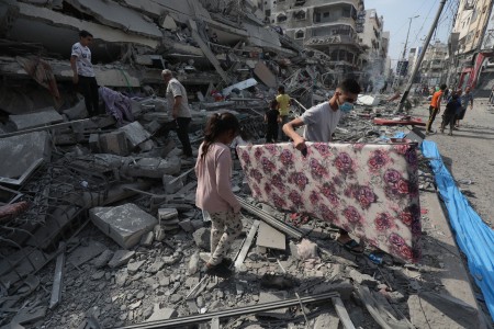Palestijnen inspecteren de ruïnes van de Aklouk Toren die verwoest werd door Israëlische luchtaanvallen in Gaza Stad op 8 oktober 2023.