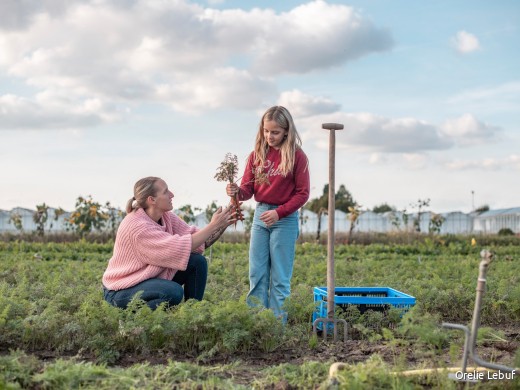 Een vrouw en een meisje aan het werk op een landbouwveld